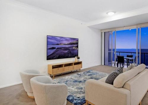ゴールドコーストにあるLevel 45 Luxury Sub-Penthouse in Towers of Chevron - Hosted by Coastal Letting Co.のリビングルーム(椅子、壁掛けテレビ付)
