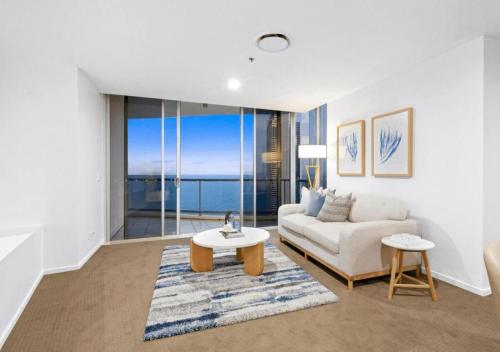 ゴールドコーストにあるLevel 45 Luxury Sub-Penthouse in Towers of Chevron - Hosted by Coastal Letting Co.のソファとテーブルのあるリビングルーム
