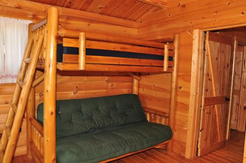 - une chambre avec des lits superposés dans une cabane en rondins dans l'établissement Fremont RV Campground Cottage 21, à Fremont