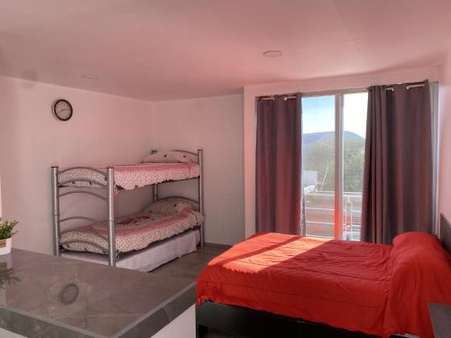 Un dormitorio con dos literas y una ventana. en Casa Mezquite, en Tequisquiapan