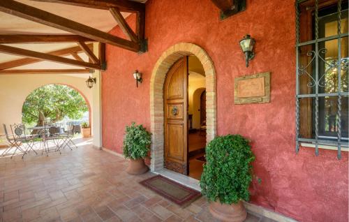 una casa con una pared roja con una puerta de madera en Gorgeous Home In Rivodutri, en Apoleggia