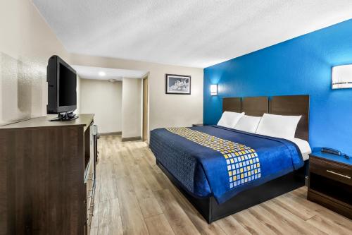 a hotel room with a bed and a flat screen tv at Royal Inn in Bellmawr