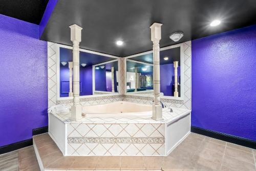 a bathroom with a tub and purple walls at Royal Inn in Bellmawr