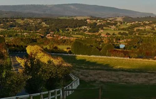a view of a field with trees and a fence at 'Wallan luxury house in Wallan