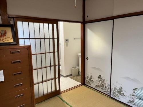 a room with sliding glass doors and a bathroom at D-pdal Inn 1F - Vacation STAY 14134 in Tokyo