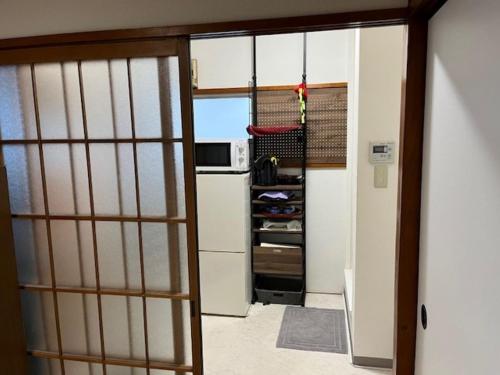 an open door to a kitchen with a refrigerator at D-pdal Inn 1F - Vacation STAY 14134 in Tokyo