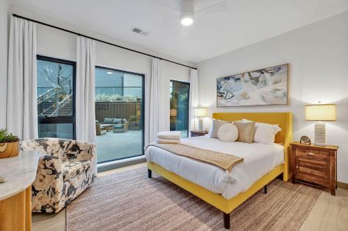 a bedroom with a bed and a chair and windows at Hyve - Southern Comfort - Walk to Broadway in Nashville