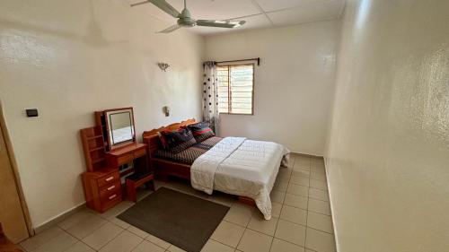 a bedroom with a bed and a mirror and a television at Eonka Serviced Homes in Kika