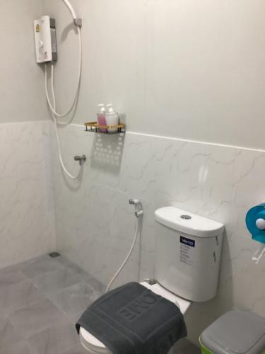 a bathroom with a toilet with a black seat at Sunshine bungalow in Ban Saiyuan (1)