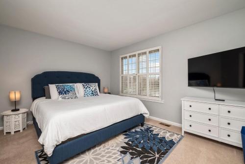 a bedroom with a large bed and a flat screen tv at Waterfront Retreat with Dock, Firepit & Theater in Portsmouth