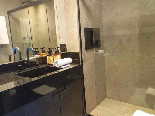 Un baño con ducha, lavabo y espejo. en Hotel B Tree Premium Jardins, en São Paulo
