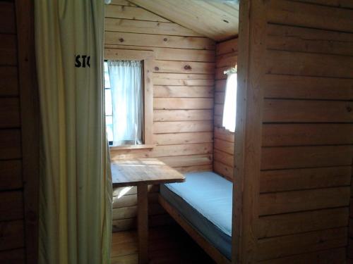 a small cabin with a bed and a window at Fremont RV Campground Cabin 8 in Fremont