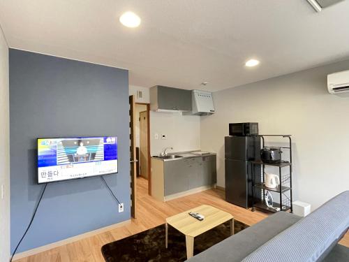 a living room with a flat screen tv on a wall at アムホテル in Tokyo