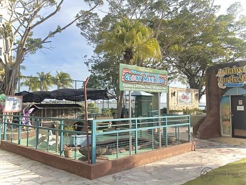 a restaurant with chickens in a cage in a park at Irama Kopa - Glory Beach Resort in Port Dickson