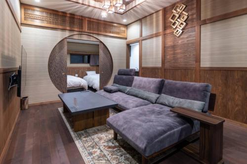 a living room with a couch and a bed at Tomiken in Nozawa Onsen