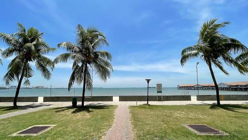 two palm trees and a dirt road near the beach at Irama Kopa - Glory Beach Resort in Port Dickson
