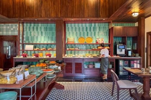 een man aan een aanrecht in een keuken bij U Luang Prabang in Luang Prabang