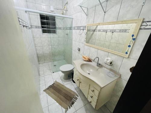 a bathroom with a sink and a shower and a toilet at Chalé em ilhabela in Ilhabela