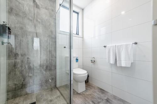 a bathroom with a toilet and a glass shower at The Inner-North Escape - Free Parking & Wifi in Melbourne