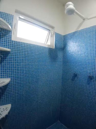 a bathroom with a blue tiled shower with a window at En la 96 in Cancún