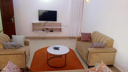 a living room with two chairs and a tv at Wiston Services in Cotonou