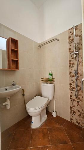 a bathroom with a toilet and a sink at Cute Room 1 at Pondok Raima SYARIAH in Gresik