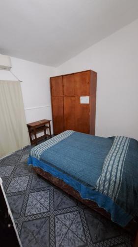 a bedroom with a bed and a wooden headboard at Departamento familiar con pileta exclusiva in Villa Carlos Paz
