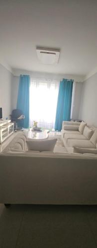 a room with a large bed with blue curtains at Chichi homes sabaki green estate in Nairobi