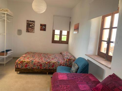 Habitación con 2 camas, sofá y ventanas en El Oasis de los Jarales, en Almayate Alto