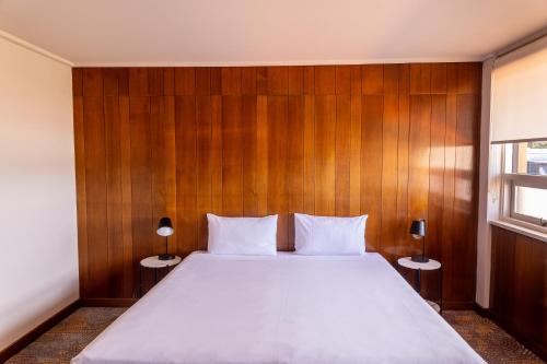 a bedroom with a large bed with a wooden wall at Black Buffalo in Hobart