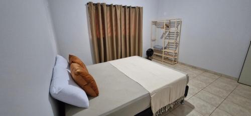 a bedroom with a bed with a pillow on it at Apartamento central completo in Tangara da Serra