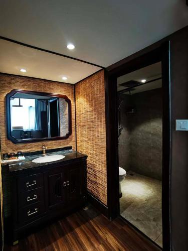 a bathroom with a sink and a tv on the wall at Zhifang Hotel in Datong
