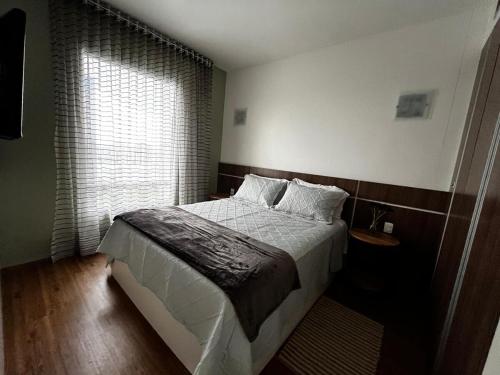a bedroom with a large bed and a window at Flat dentro de hotel de Luxo proximo ao shopping in Manaus