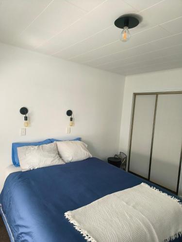 ein Schlafzimmer mit einem blauen Bett und einer Decke in der Unterkunft City Town House - Unit in Christchurch