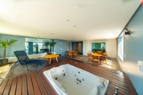 a bath tub sitting on top of a wooden deck at Flat dentro de hotel de Luxo proximo ao shopping in Manaus