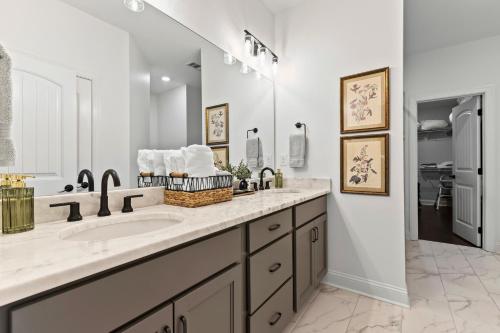 a bathroom with a sink and a large mirror at Farmville Lakes Tailored Townhouse in Auburn