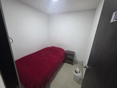 a small bedroom with a red bed in a room at Hospedaje & Restaurante Rancho Grande Tocancipá SAS in Tocancipá