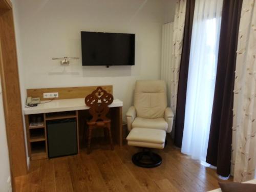 a room with a desk and a chair and a television at Penzion Tavcar in Ljubljana