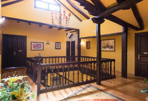 sala de estar con escalera de madera y paredes amarillas en Hotel La Posada Regia, en León