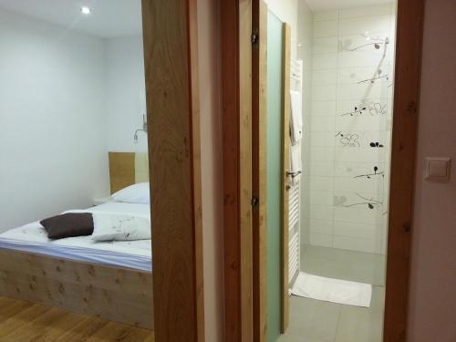 a bedroom with a bed and a shower at Penzion Tavcar in Ljubljana