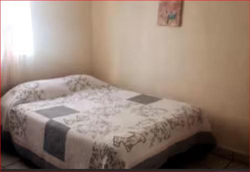 Un dormitorio con una cama con una manta encima. en AlegreA -2 br apartment with secure parking included, en Playas de Rosarito