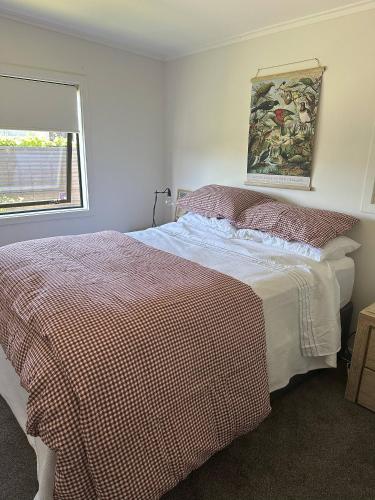 a bedroom with a bed and a window at Lovely Wanaka Crib in Wanaka