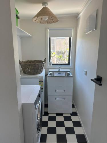 a small kitchen with a sink and a checkered floor at Lovely Wanaka Crib in Wanaka