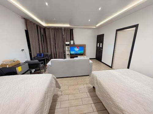 a hotel room with two beds and a flat screen tv at Villas Na-tiva Guanacaste in Plazuela