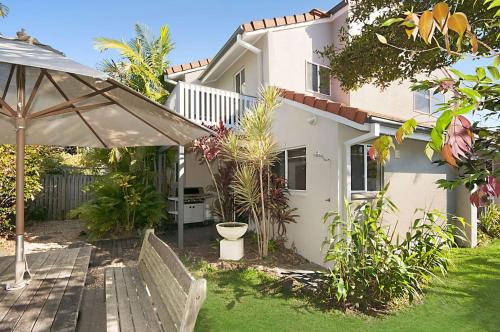a house with a garden and an umbrella at Waitui 1 - 3 Somerset Street in Byron Bay