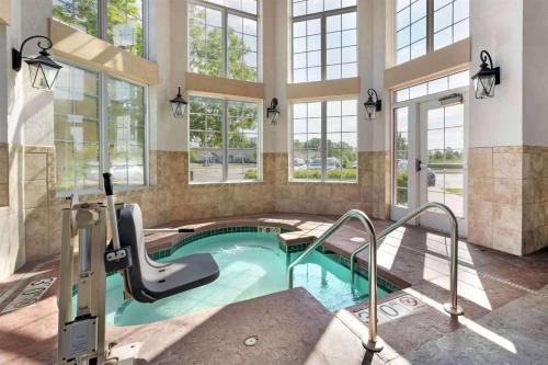 a pool with a slide in a building with windows at Wyndham Garden Appleton in Appleton