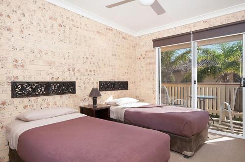 a bedroom with two beds and a balcony at Waitui 1 - 3 Somerset Street in Byron Bay