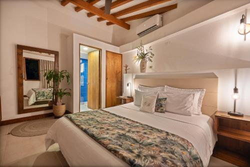 a bedroom with a large bed and a mirror at Casa Bixa Hotel Boutique by HMC - Mayores de 12 años - in Santa Fe de Antioquia