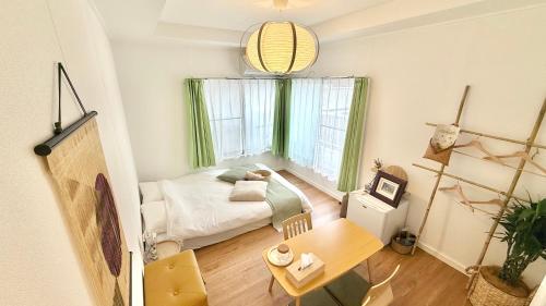 een kleine kamer met een bed en een tafel bij 民泊&guest house NOOK NOOK ディズニーまで往路のみ無料送迎 in Tokyo
