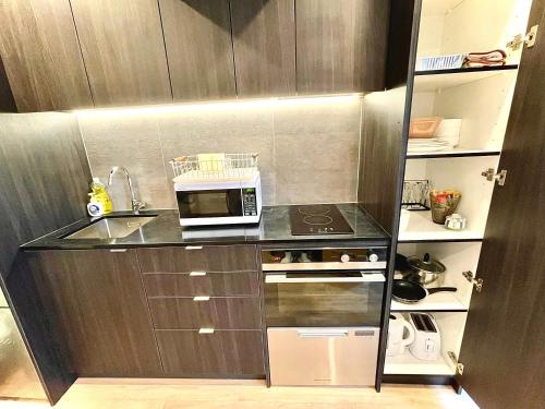 a small kitchen with a microwave on a counter at Modern apartment in the city center in Auckland